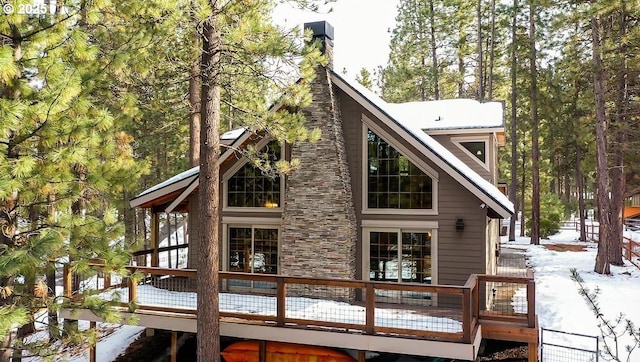 snow covered property featuring a wooden deck