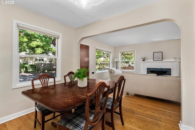 2153 SE 20th Ave, Portland, OR 97214 - dining room with arched walkways, wood finished floors, baseboards, and a fireplace
