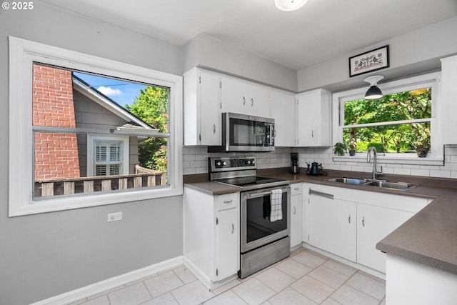 2153 SE 20th Ave, Portland, OR 97214 - kitchen featuring appliances with stainless steel finishes, a sink, dark countertops, and light tile patterned floors