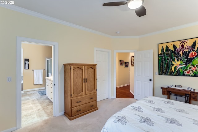 bedroom with crown molding, light colored carpet, ceiling fan, and ensuite bath