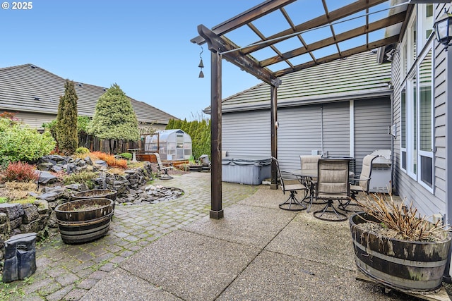 view of patio with an outbuilding, a hot tub, and a pergola