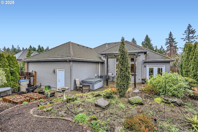 back of house with french doors and a hot tub