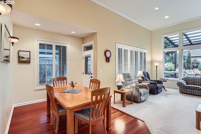 dining space with ornamental molding and dark wood-type flooring