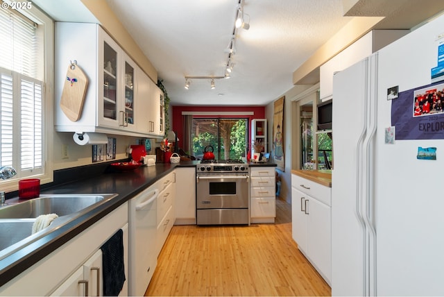 4825 SE 33rd Ave, Portland, OR 97202 - kitchen featuring stainless steel appliances, white cabinetry, and light wood finished floors