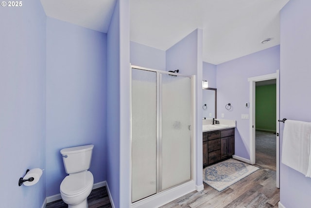 69857 Stage Rd, North Bend, OR 97459 - bathroom with a stall shower, vanity, wood finished floors, toilet, and baseboards
