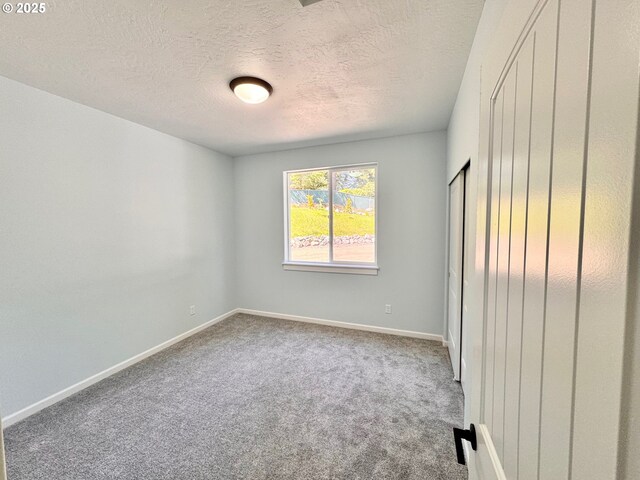 69857 Stage Rd, North Bend, OR 97459 - unfurnished bedroom featuring carpet, a textured ceiling, and baseboards