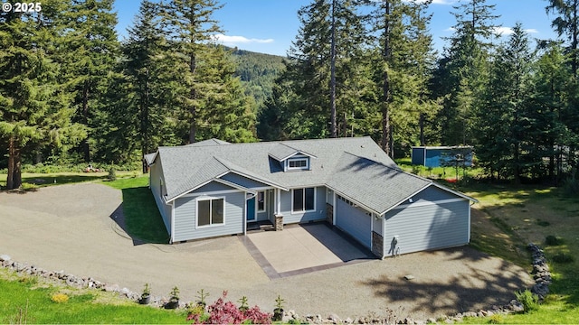 69857 Stage Rd, North Bend, OR 97459 - view of front of home featuring driveway, a forest view, a garage, and a shingled roof