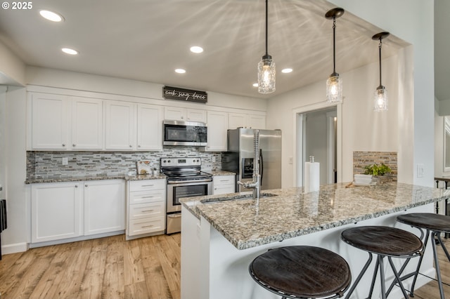 10840 SW Black Diamond Way, Portland, OR 97223 - kitchen with stainless steel appliances, white cabinets, backsplash, a peninsula, and recessed lighting