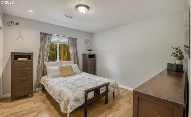 10840 SW Black Diamond Way, Portland, OR 97223 - bedroom with light wood finished floors, a textured ceiling, and baseboards