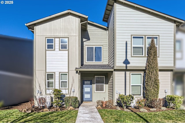 view of front of home with a front lawn and ac unit