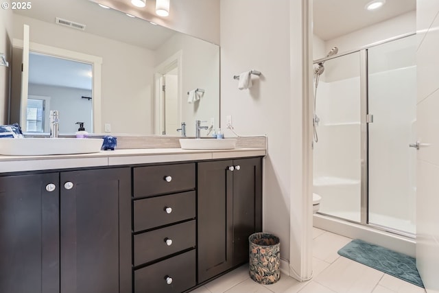 bathroom featuring vanity, a shower with shower door, tile patterned floors, and toilet