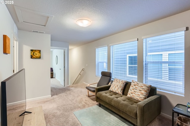 living room featuring plenty of natural light, light colored carpet, and a textured ceiling