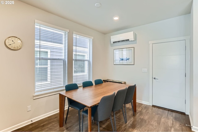 dining room featuring dark wood-type flooring and an AC wall unit