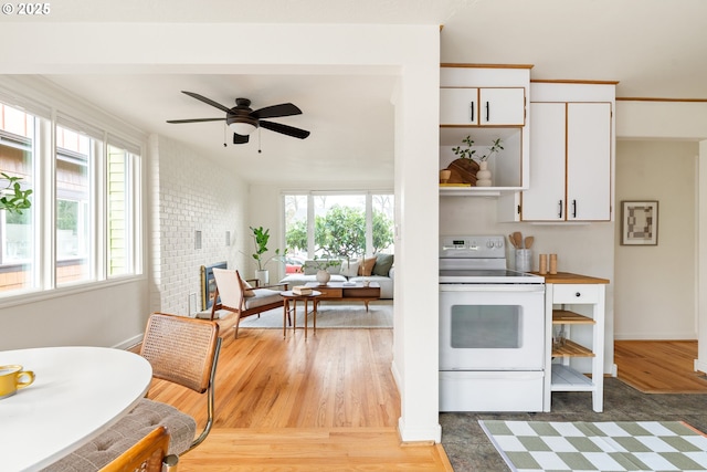 kitchen with a healthy amount of sunlight, white cabinetry, white electric stove, and open shelves