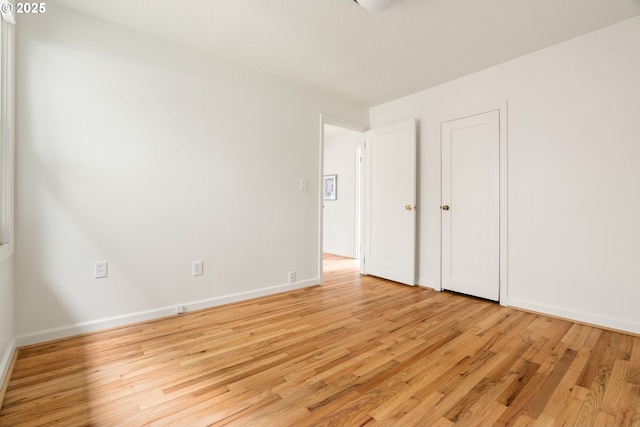 unfurnished bedroom with light wood-style flooring and baseboards