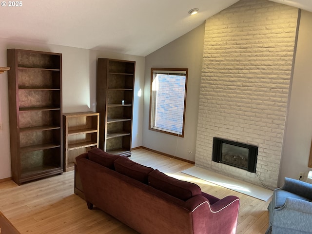 living room featuring a brick fireplace, lofted ceiling, and light hardwood / wood-style flooring