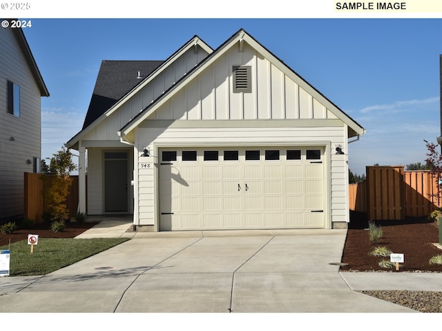 view of front facade featuring driveway, an attached garage, board and batten siding, and fence