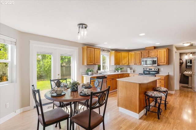1224 Alyssum Ave, Forest Grove, OR 97116 - kitchen with appliances with stainless steel finishes, light countertops, a kitchen island, baseboards, and light wood finished floors