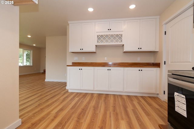 kitchen with white cabinetry, butcher block countertops, recessed lighting, and light wood-style floors
