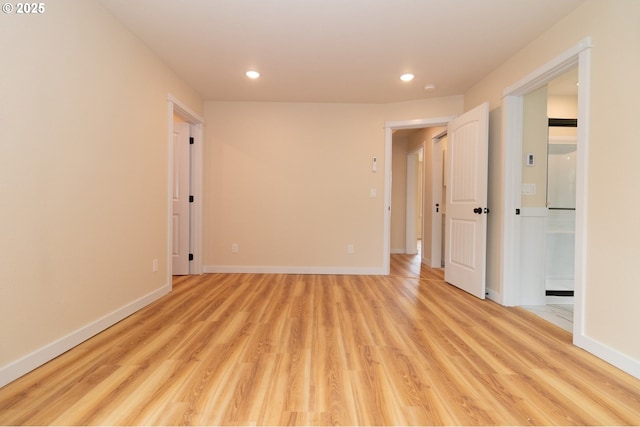 spare room featuring recessed lighting, light wood-style flooring, and baseboards