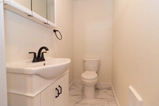 bathroom with vanity, marble finish floor, baseboards, and toilet