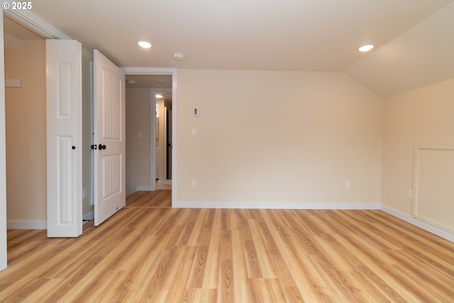 interior space featuring recessed lighting, baseboards, lofted ceiling, and light wood-type flooring