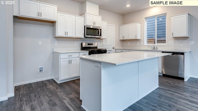 2131 NE 3rd Ave, Battle Ground, WA 98604 - kitchen with appliances with stainless steel finishes, dark wood-type flooring, white cabinetry, baseboards, and a kitchen island
