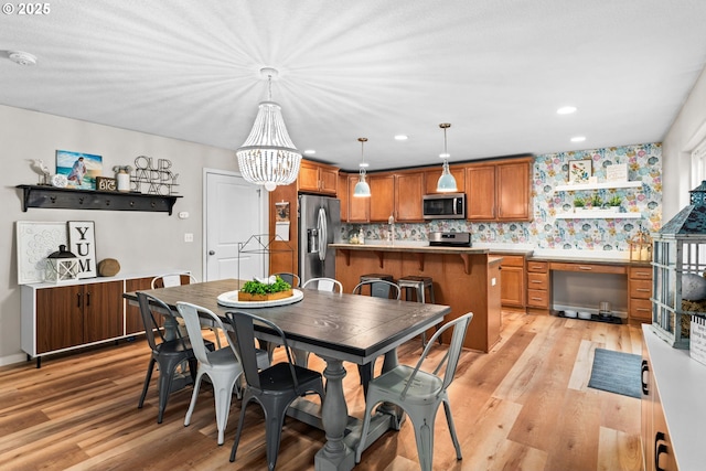 dining space featuring light hardwood / wood-style flooring and a notable chandelier