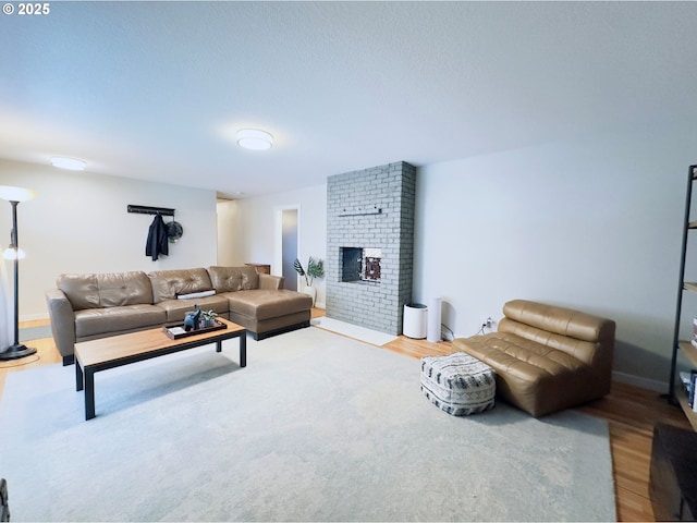 living room with baseboards, wood finished floors, and a fireplace