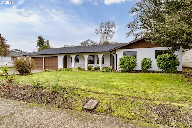 single story home with covered porch, a front lawn, and a garage