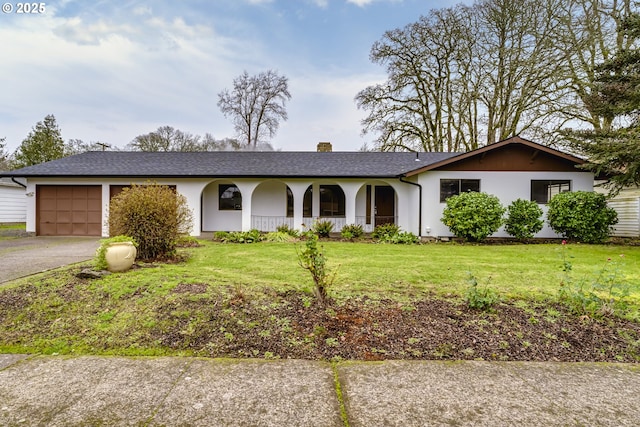 ranch-style house featuring covered porch, a front lawn, and a garage