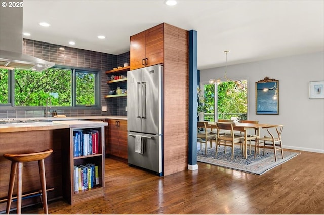 2975 SW Canterbury Ln, Portland, OR 97205 - kitchen featuring high end refrigerator, open shelves, island exhaust hood, light countertops, and decorative backsplash