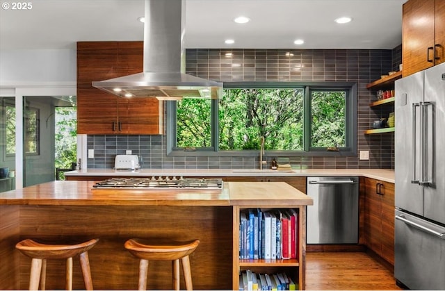 2975 SW Canterbury Ln, Portland, OR 97205 - kitchen with appliances with stainless steel finishes, wooden counters, open shelves, island range hood, and recessed lighting