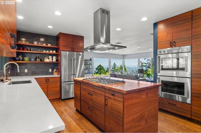2975 SW Canterbury Ln, Portland, OR 97205 - kitchen featuring stainless steel appliances, island exhaust hood, a sink, a center island, and recessed lighting