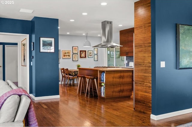 2975 SW Canterbury Ln, Portland, OR 97205 - kitchen with island range hood, baseboards, wood finished floors, recessed lighting, and stainless steel gas stovetop