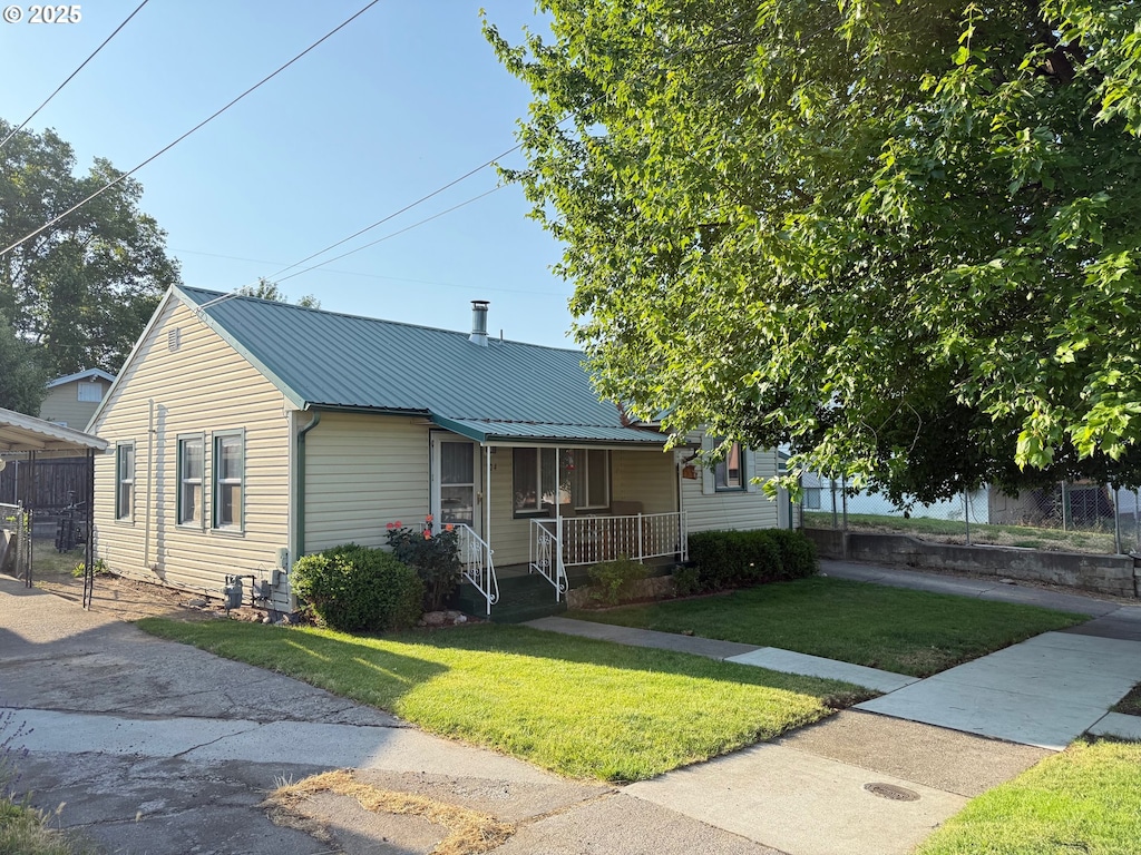 104 NW 12th St, Pendleton, OR 97801 - view of front of house featuring a porch, a front lawn, and metal roof