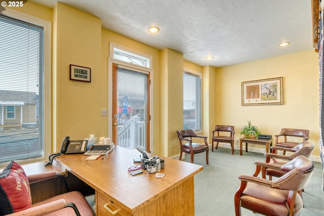 carpeted office featuring a textured ceiling