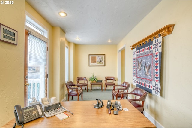 dining space with a textured ceiling and carpet flooring