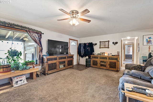 living area featuring carpet, a ceiling fan, and healthy amount of natural light