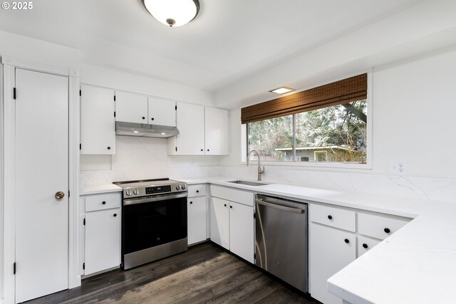 kitchen with a sink, stainless steel appliances, dark wood-type flooring, white cabinets, and under cabinet range hood