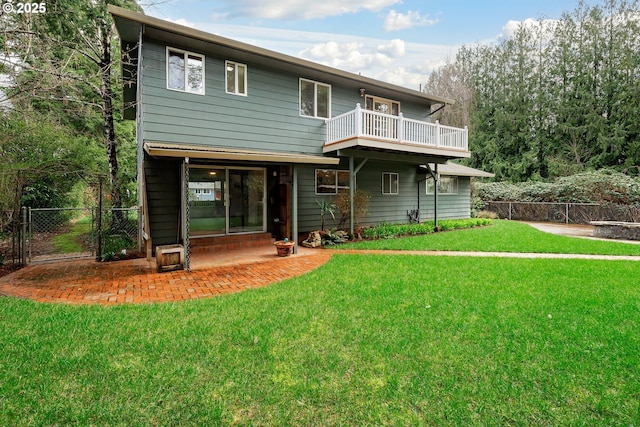 rear view of house featuring a gate, a patio, fence, a yard, and a balcony