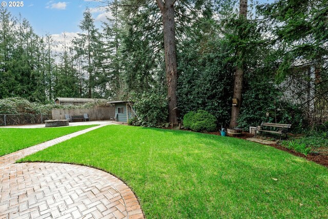 view of yard with an outbuilding, a patio area, and fence