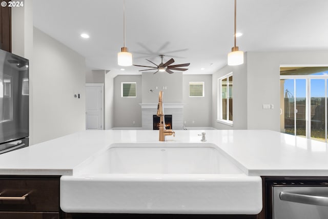 kitchen with ceiling fan, sink, stainless steel dishwasher, and decorative light fixtures