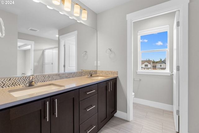 bathroom featuring toilet, vanity, and an enclosed shower