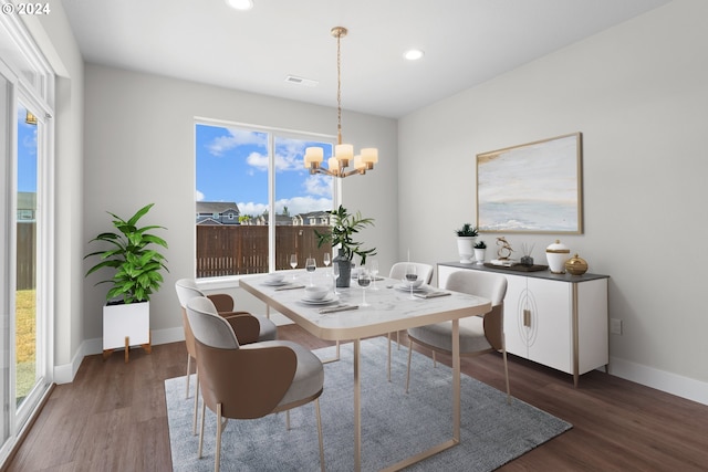 dining area featuring a wealth of natural light, dark hardwood / wood-style flooring, and a notable chandelier