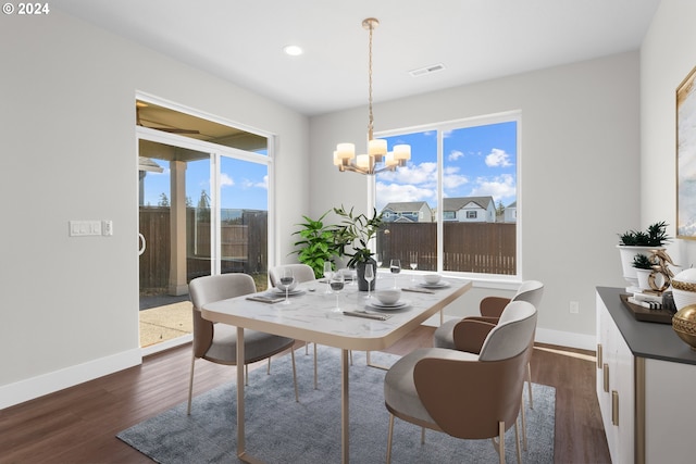 dining area with an inviting chandelier and dark hardwood / wood-style flooring