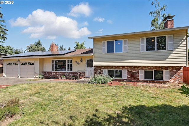 18735 NE Wasco Ct, Portland, OR 97230 - tri-level home featuring a chimney, brick siding, an attached garage, solar panels, and driveway