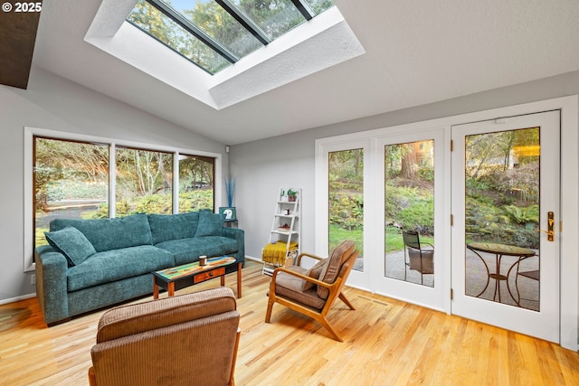 sunroom / solarium featuring lofted ceiling with skylight