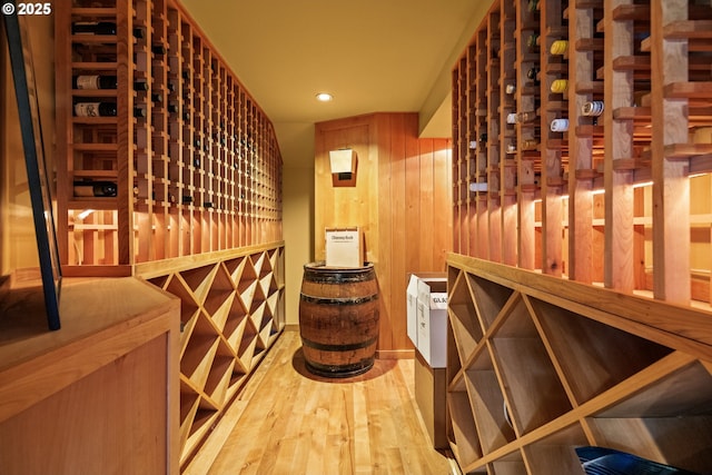 wine cellar featuring wooden walls, wood finished floors, and recessed lighting