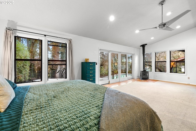 bedroom with a wood stove, access to exterior, vaulted ceiling, and recessed lighting